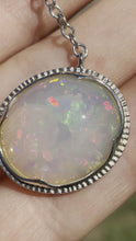 Load and play video in Gallery viewer, large white opal cabochon with rainbow play of colour, gem quality opal necklace by curtis r jewel
