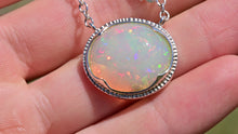 Load and play video in Gallery viewer, large white opal cabochon with rainbow play of colour, gem quality opal necklace by curtis r jewel
